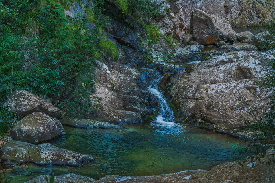 Clear mountain stream flowing through rocky pools at Rust-en-Vrede Waterfall near Oudtshoorn in the Western Cape of South Africa.