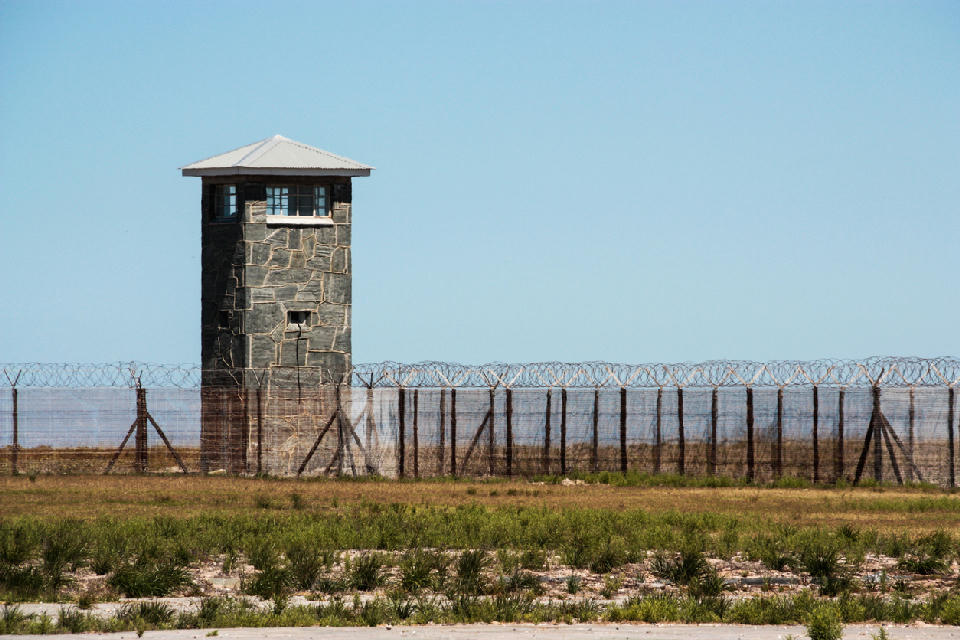 Guard tower and barbed wire fence at Robben Island prison near Cape Town, South Africa.
