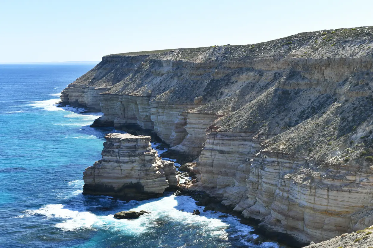 Island Rock rising offshore beneath the layered coastal cliffs of Kalbarri National Park.