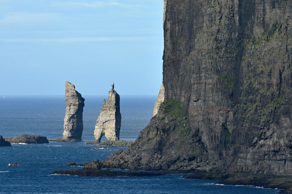 Two vertical sea stacks of Risin og Kellingin rising from the Atlantic Ocean near Tjørnuvík, Streymoy, Faroe Islands, with sheer coastal cliffs in the foreground.