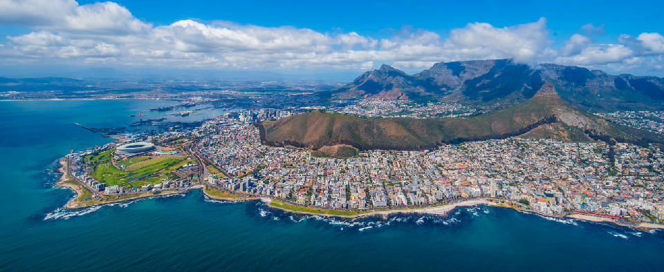 Panoramic aerial photograph of Cape Town coastline showing the Atlantic Ocean, Sea Point and Green Point, Signal Hill ridge, Lion’s Head peak and the Table Mountain massif in the background.
