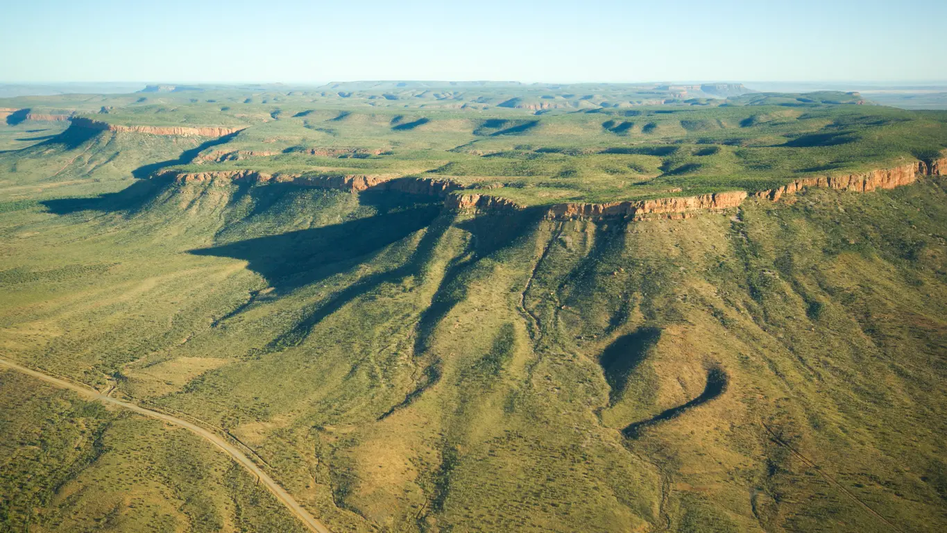 Aerial view of the Cockburn Range showing long red escarpments, deeply eroded slopes and vast rugged Kimberley wilderness.