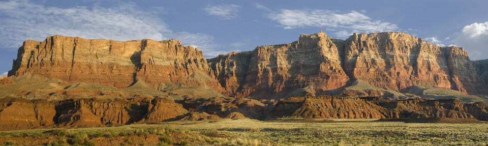 Layered red sandstone cliffs of Vermilion Cliffs above desert landscape in northern Arizona