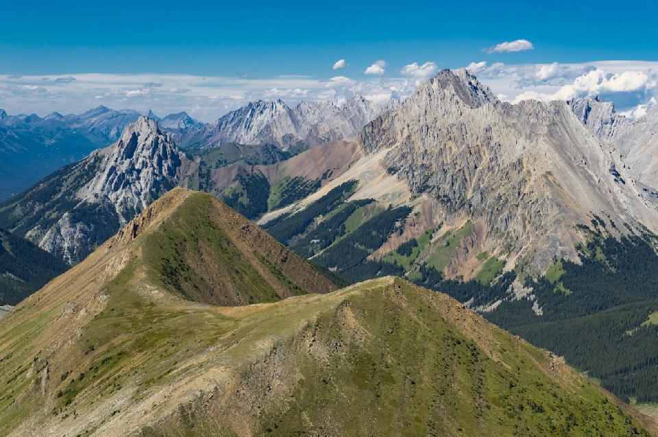 High alpine ridge with layered mountain peaks and rugged rock formations in Kananaskis Country, Alberta, Canada.