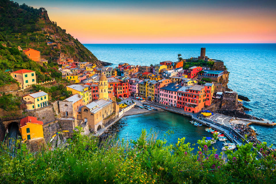 Sunset view of Vernazza, with colourful Mediterranean buildings on a hillside within Cinque Terre National Park, Liguria, Italy.