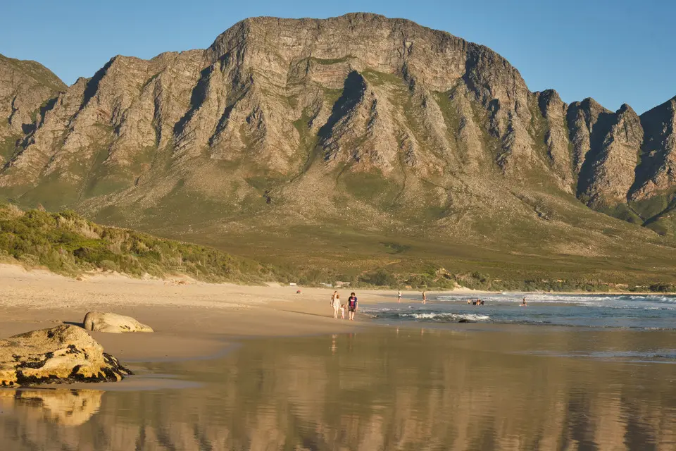 Wet sand reflections and coastal mountain scenery at Kogel Bay along the Kogelberg coastline in the Western Cape, South Africa.