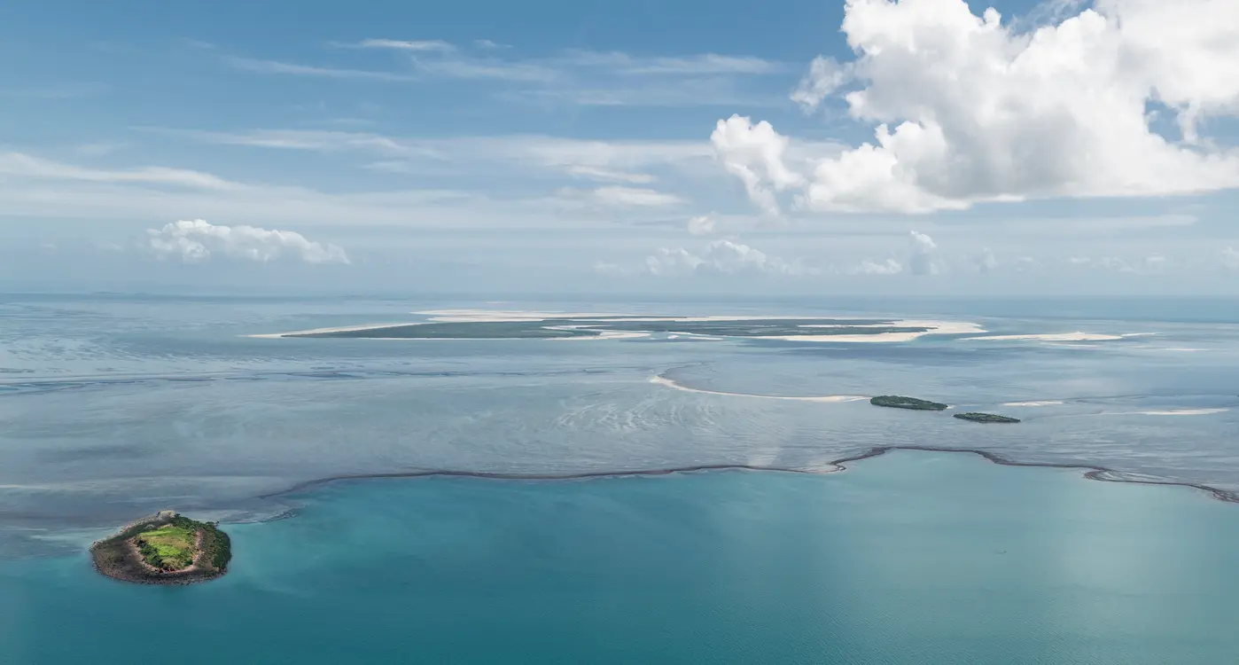 Aerial view across Montgomery Reef as exposed reef and tidal channels emerge from the turquoise waters of the Kimberley coast.