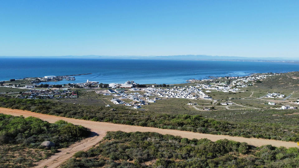 Panoramic view of St Helena Bay showing the harbour, coastal settlements, shrub-covered hills and the sheltered waters of the Atlantic Ocean.