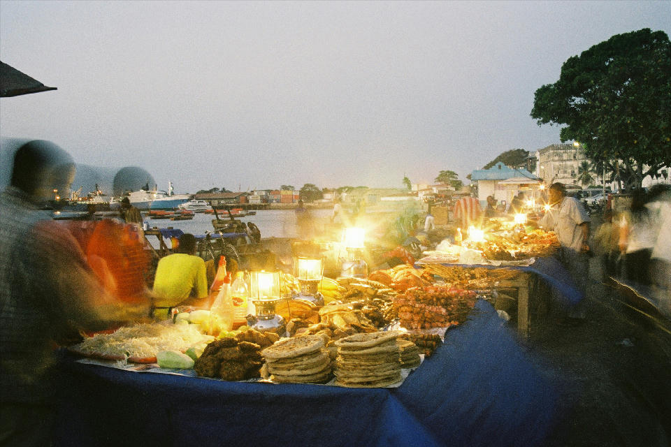 Food stalls illuminated by lanterns at the lively evening market in Forodhani Gardens, Stone Town, Zanzibar.