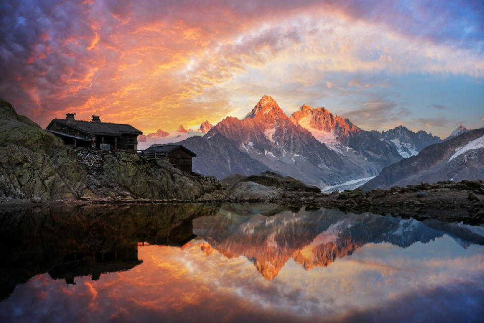 Lac Blanc at sunset with reflection of Mont Blanc Massif peaks and alpine hut in Chamonix, French Alps.