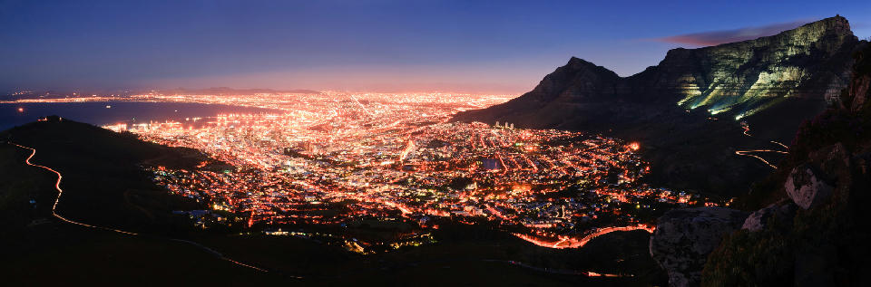 Night view of Cape Town City Bowl with illuminated streets and Table Mountain.