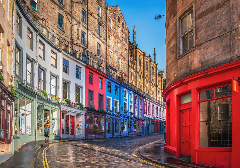 Victoria Street in Edinburgh with colourful buildings and wet cobblestones.
