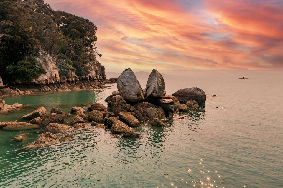 Split Apple Rock sea stack at sunrise off the coast near Kaiteriteri in Abel Tasman National Park, New Zealand.