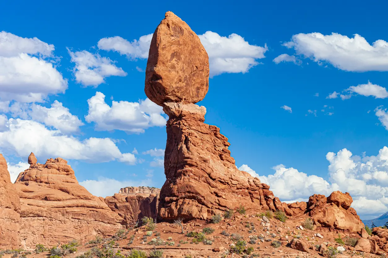 Balanced Rock sandstone formation perched on a narrow base under blue sky in Arches National Park Utah