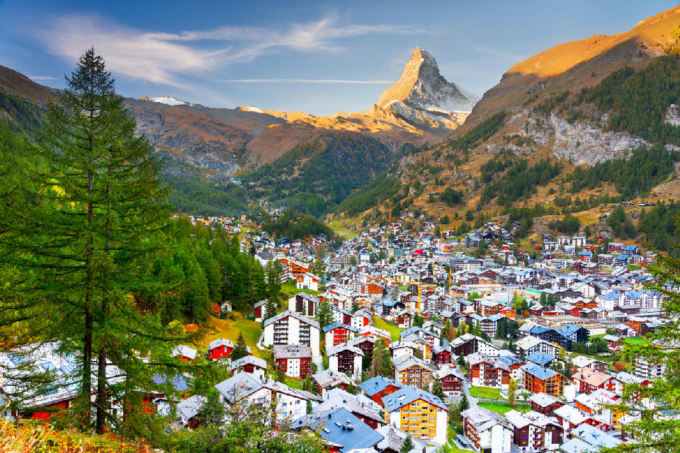 Zermatt village with traditional alpine chalets below the Matterhorn peak in early morning light, Switzerland