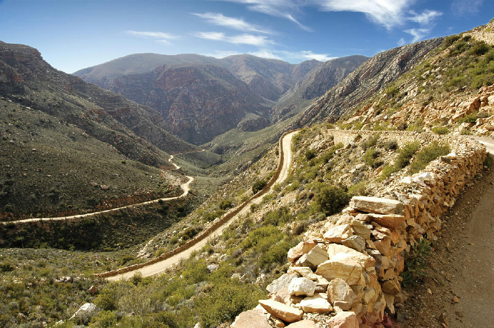 Winding gravel road descending through the Swartberg Pass in the rugged Swartberg Mountains of the Klein Karoo in South Africa.