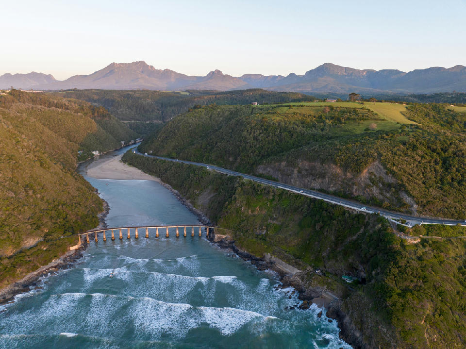 Aerial view of the Kaaimans River Mouth and historic railway bridge near Wilderness, where the river meets the Indian Ocean along South Africa's Garden Route.