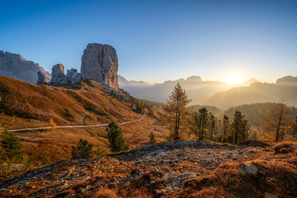 Sunrise over Cinque Torri, with the five rock towers rising from autumn alpine landscape in the Dolomites, Italy.