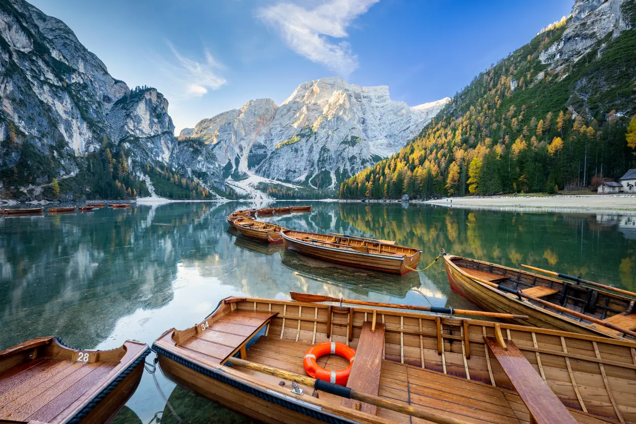 Landscape view of Lago di Braies surrounded by forest and Dolomite mountain peaks in northern Italy.