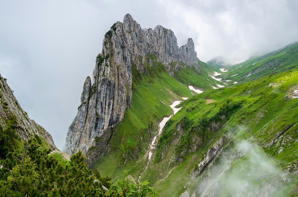 Saxer Lücke ridge with jagged limestone cliffs and green alpine slopes in Appenzell Alps, Switzerland.