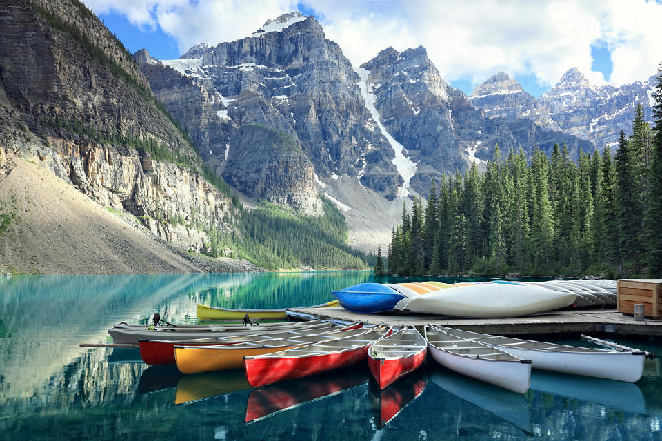 Canoes on Moraine Lake with turquoise water and mountain peaks in Banff National Park, Alberta, Canada