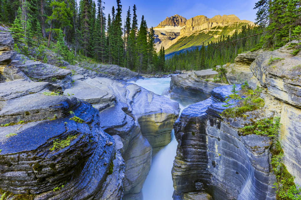 Mistaya Canyon with smooth, sculpted rock walls and flowing glacial river along the Icefields Parkway in Banff National Park