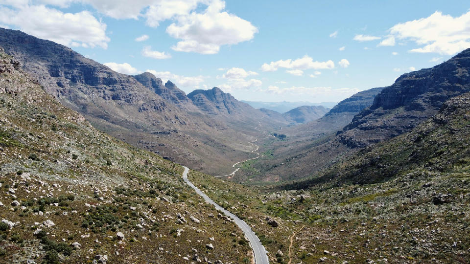 View from Uitkyk Pass with winding road descending through a sandstone valley in the Cederberg Mountains.