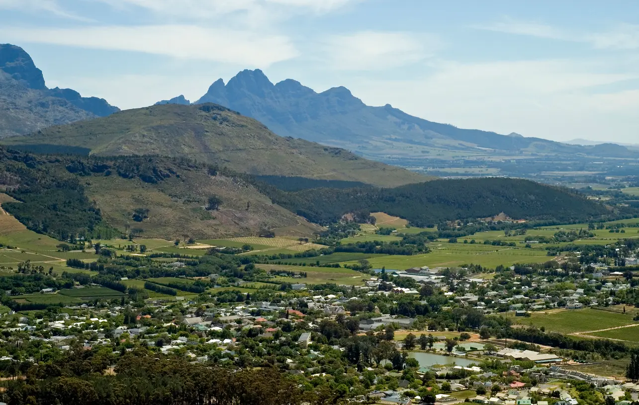 Elevated view of Franschhoek Village, vineyards, and mountain landscape from Franschhoek Pass in the Western Cape, South Africa.