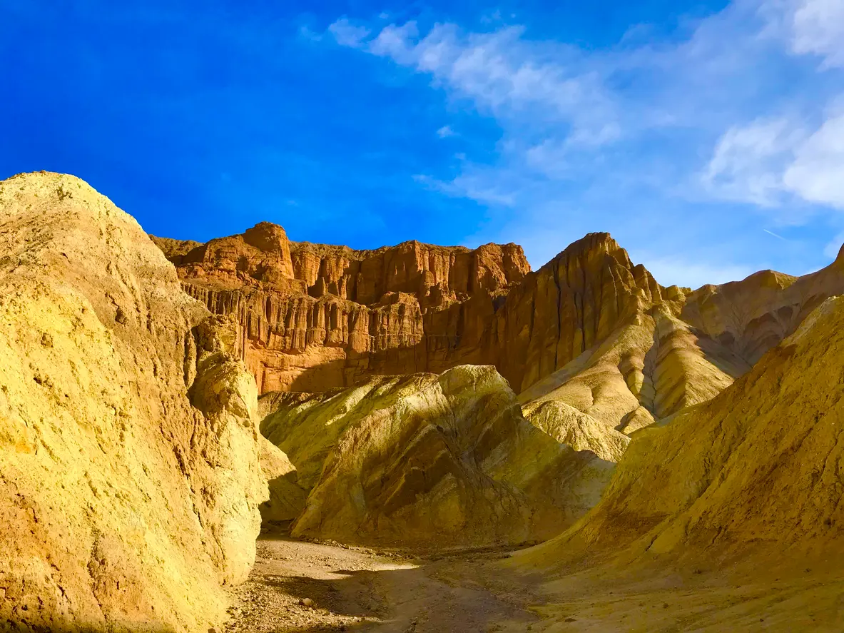 Golden Canyon in Death Valley National Park California with yellow badlands walls leading to Red Cathedral rock formations