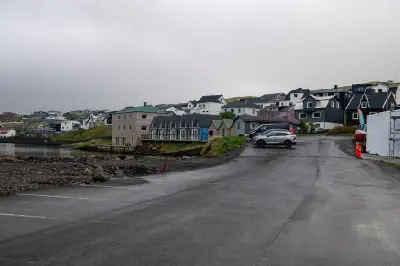Waterfront parking area and houses along the harbour in Sørvágur on Vágar Island, Faroe Islands.