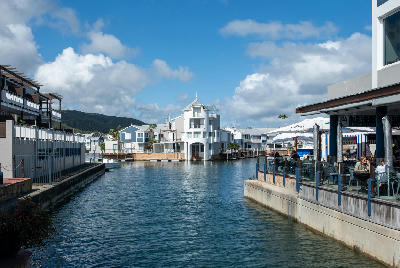 Waterfront canal lined with homes, restaurants and moored boats on Thesen Island in Knysna, South Africa.