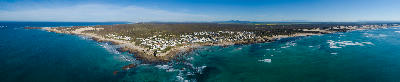 Aerial view of Arniston village, rocky shoreline, and turquoise ocean along the Southern Overberg coast of South Africa.