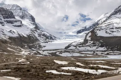 Athabasca Glacier flowing between snow-covered peaks within the Columbia Icefield in Jasper National Park, Alberta, Canada.