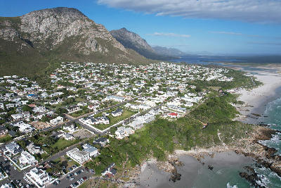 Aerial panorama of Hermanus in South Africa showing Walker Bay, coastal cliffs, beaches, and mountains along the Whale Coast.