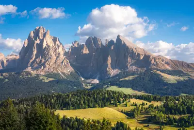 Alpe di Siusi (Seiser Alm) in the Dolomites, with the Sassolungo and Sassopiatto mountains rising above alpine meadows in South Tyrol, Italy.