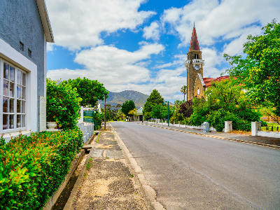 Church Street in Stanford with the NG Kerk church tower, historic buildings, and mountain backdrop in the Western Cape, South Africa.