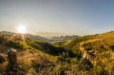 Wide landscape view of Lisbon Falls and the Lisbon River gorge surrounded by grassland hills and escarpment scenery in Mpumalanga.