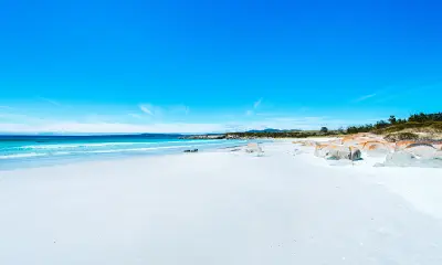 White-sand beach, turquoise sea and orange lichen-covered granite at Binalong Bay, Tasmania.
