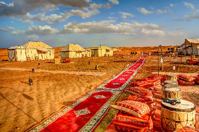 Luxury Sahara desert camp near Erg Chebbi with traditional carpets and tents in Merzouga, Morocco.