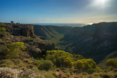Rugged slopes and native vegetation frame Charles Knife Canyon with the Indian Ocean visible beyond.
