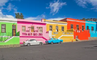 Colorful pastel houses with decorative balconies on a sloping street in Bo-Kaap, Cape Town, South Africa.