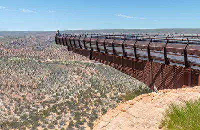 Cantilevered Kalbarri Skywalk extending over the Murchison River gorge with a visitor at the lookout.