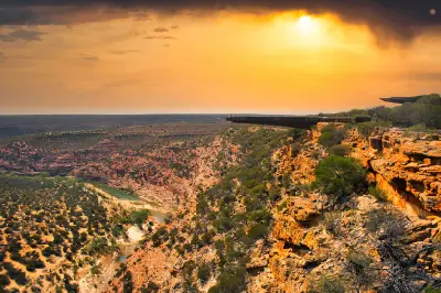Kalbarri Skywalk extends over the sandstone gorge as golden sunset light illuminates the Murchison River valley.