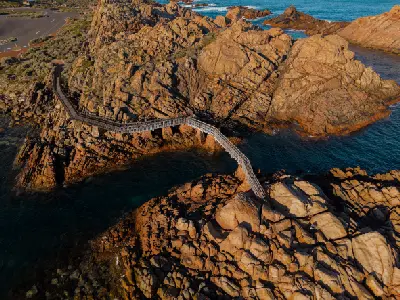 Aerial view of the Canal Rocks boardwalk crossing granite formations and ocean channels near Yallingup, Western Australia.