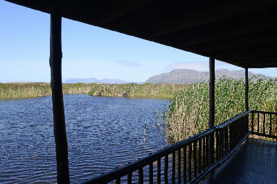 Wooden bird hide overlooking wetland lagoons and reeds at the Kleinmond Estuary and Rooisand Nature Reserve on the Overberg coast, South Africa.