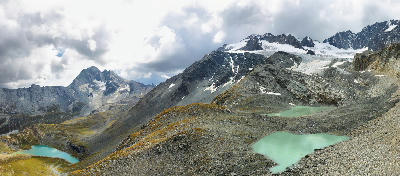 Turquoise alpine lakes below a distant glacier and rocky ridges in Vanoise National Park