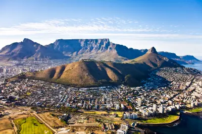 Aerial view of Cape Town with Table Mountain plateau, Lion’s Head, and Signal Hill above the coastal suburbs of Sea Point and Green Point.