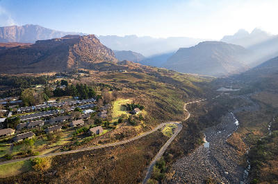 Aerial view of Cathedral Peak Hotel with Cathedral Peak and the surrounding Drakensberg Mountains in KwaZulu-Natal, South Africa.