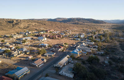 Aerial view of a small town set among rocky hills and dry landscapes in the Namaqualand region of South Africa.