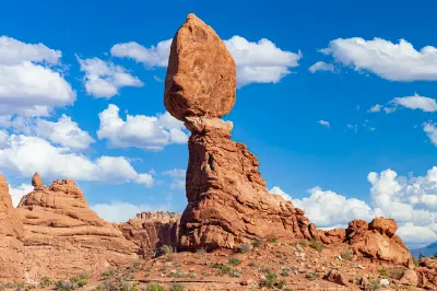 Balanced Rock sandstone formation perched on a narrow base under blue sky in Arches National Park Utah
